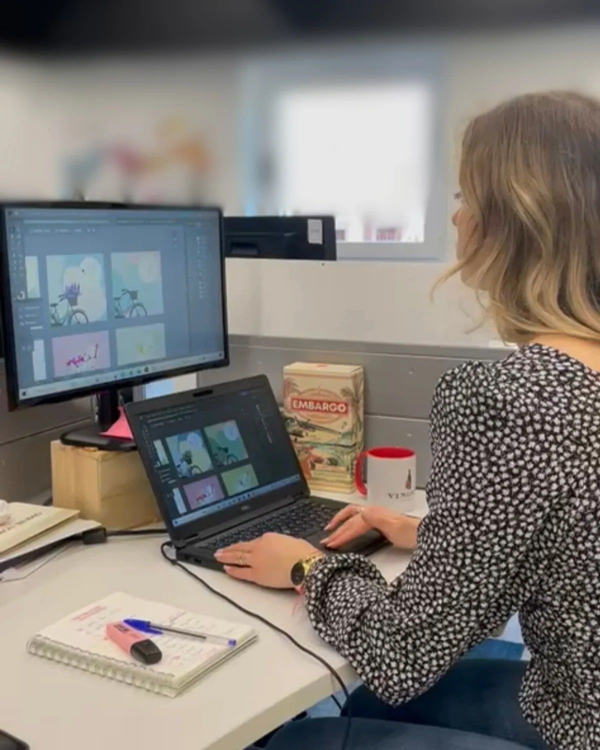 Emilie Fournier travaillant sur un site web à son bureau, devant deux écrans